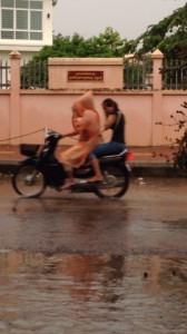 カッパを着てバイクに2人乗りするカンボジア人
