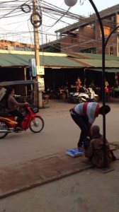 道端で体重を計るカンボジア人